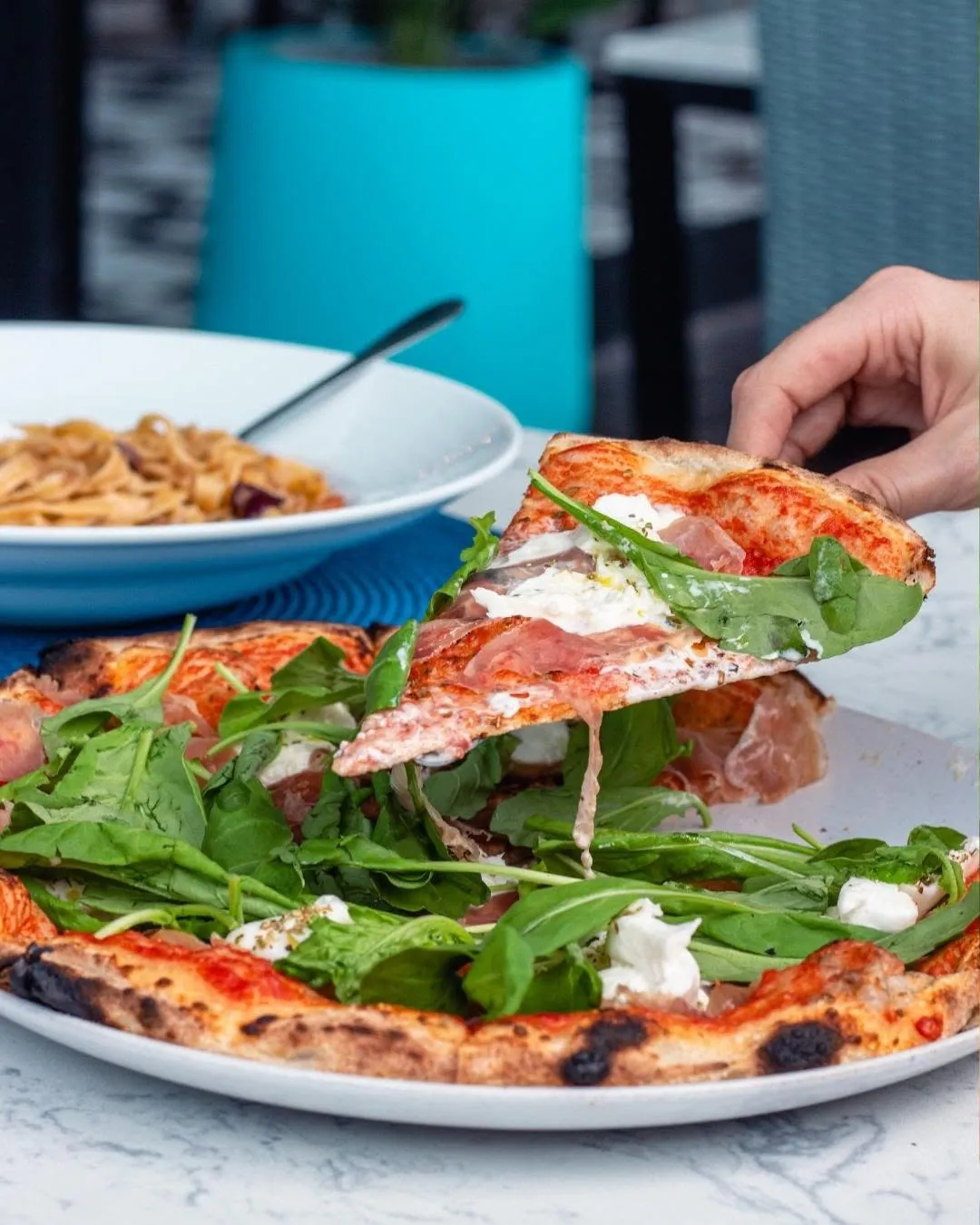 Freshly baked Italian pizza topped with prosciutto and rocket