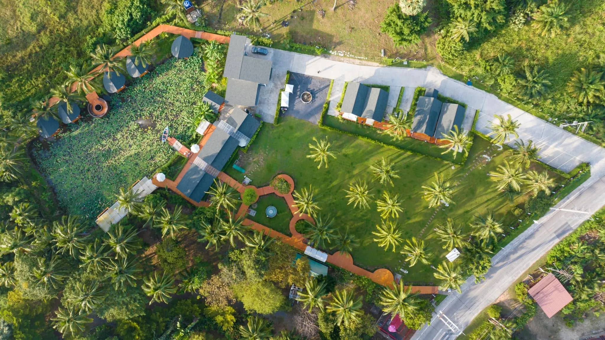 Aerial view of Baan Bo Ran Village, lotus pond and tropical grounds