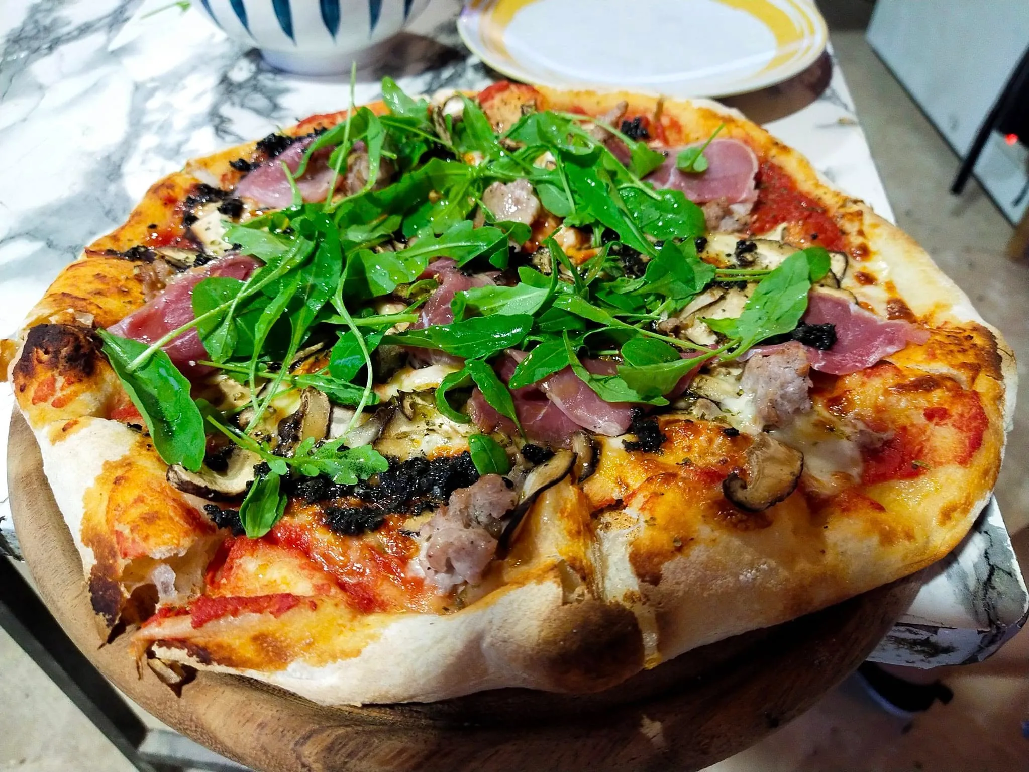 Fresh wood-fired pizza being served at Nanus Restaurant
