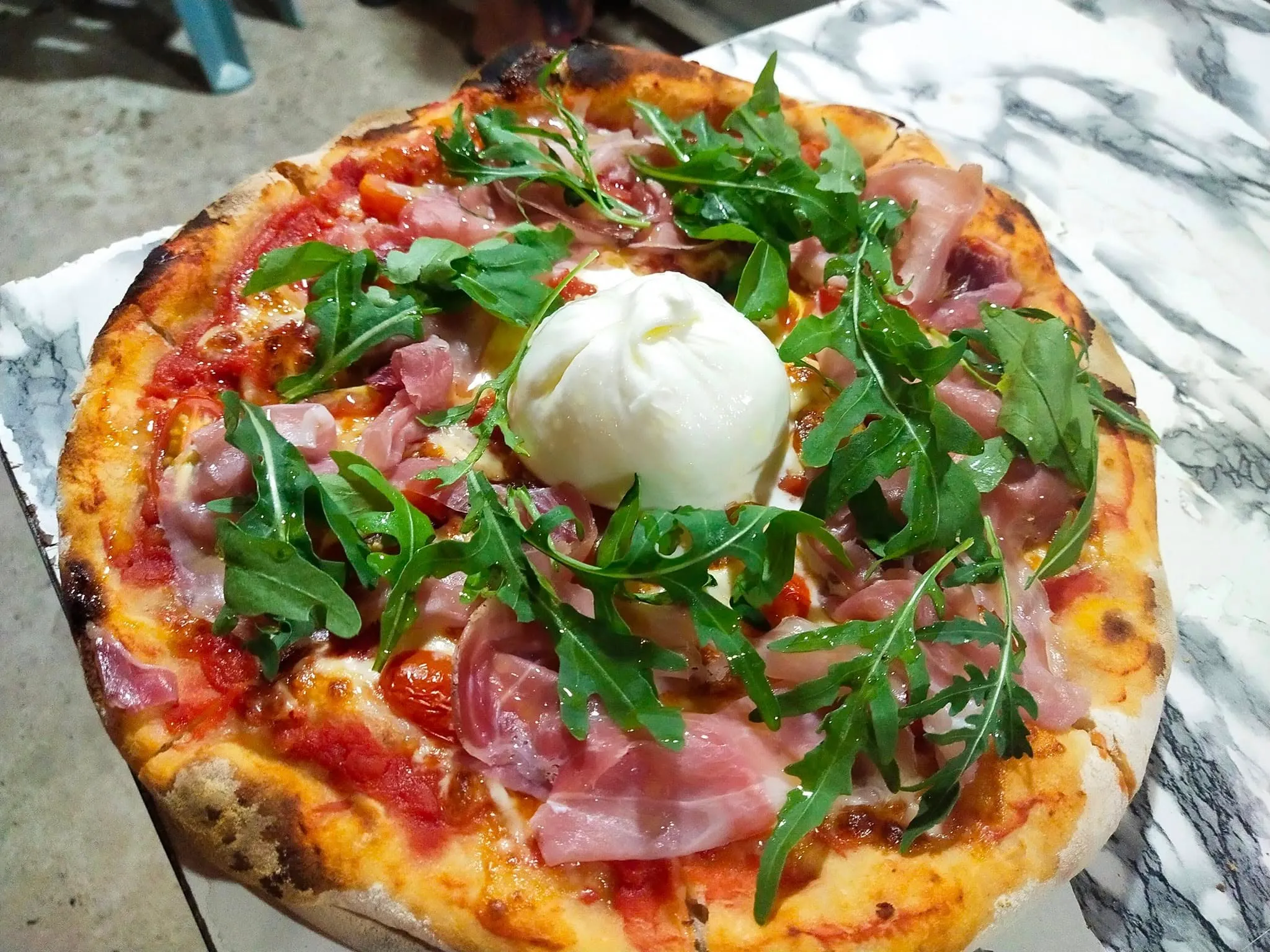 Salami pizza topped with fresh rocket